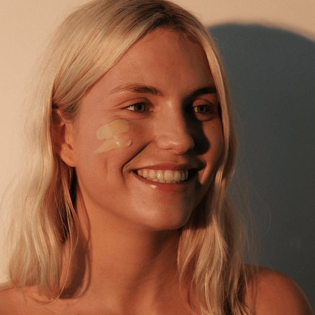 ioan getinte zonnecrème op gezicht vrouw